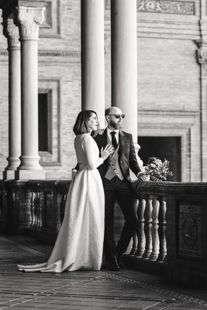 Pareja de novios entre columnas, en blanco y negro