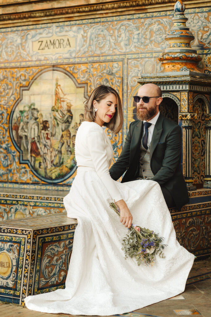 Pareja de novios junto a un mural de azulejos